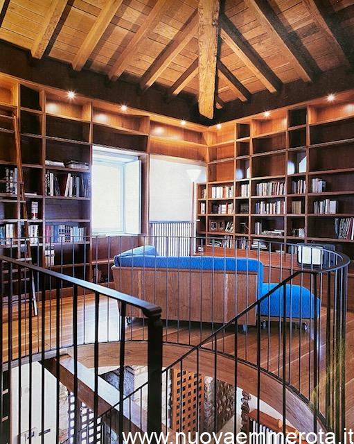 Libreria di design a tutta altezza con scala per scaffali alti.