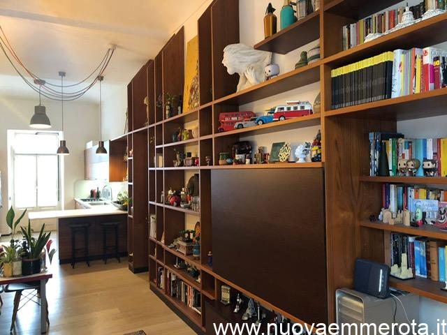 Libreria in teak del Siam con oggetti artistici e modellini lego.