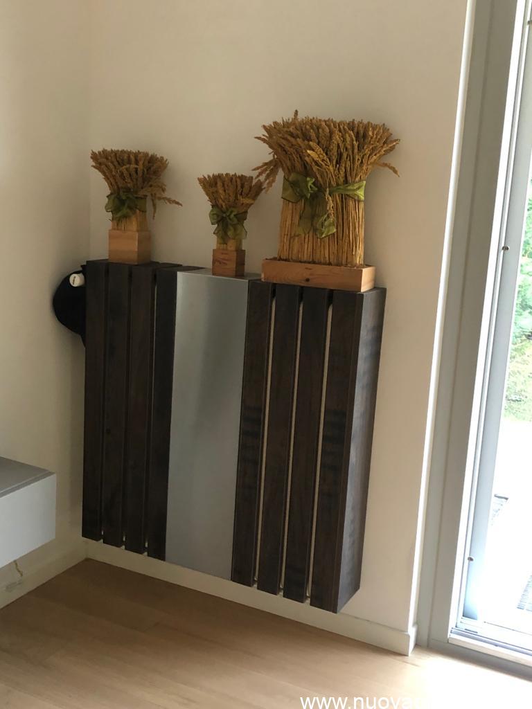 Listelli di legno e pannello in acciaio per copertura termosifone di design con decorazione.